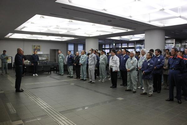 非常招集訓練で市長が話しているのを作業服姿の職員が整列して聞いている写真